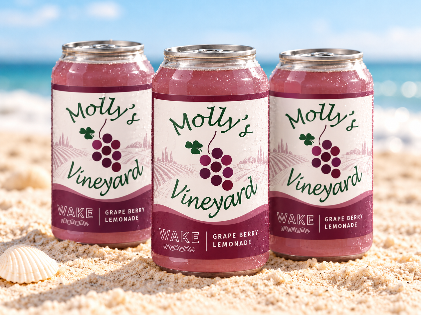 Three custom Molly's Vineyard Grape Berry Lemonade WAKE cans standing in the sand at the beach