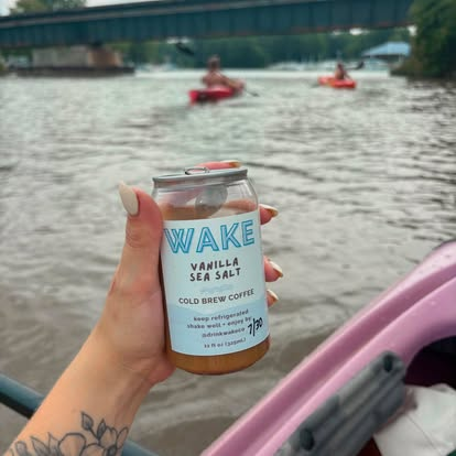 Holding a WAKE Vanilla Sea Salt can from a kayak on the river